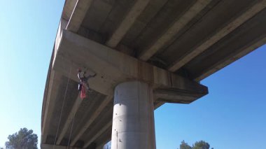 İnşaat işçisi beton köprü desteğini denetliyor ve değerlendiriyor