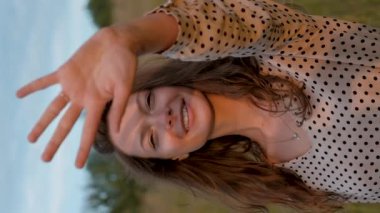 Young Woman Admires Sunlight at Sunset and Covers Herself with Her Hand