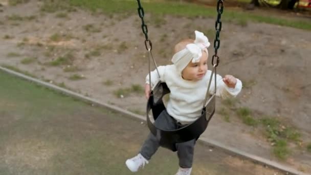 Baby Girl Bow Her Head Swinging Swing Park Little Child — 图库视频影像