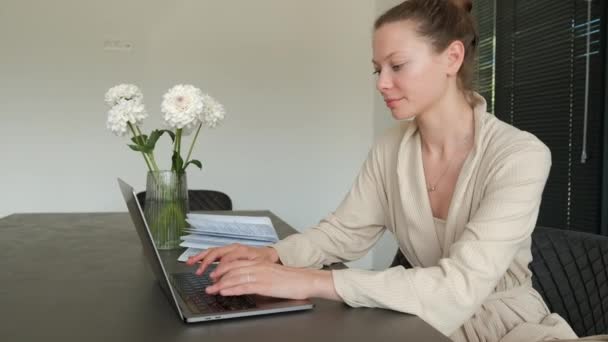 Зайнята Жінка Халаті Працює Дому Використовуючи Ноутбук Сидячи Столом Свіжими — стокове відео