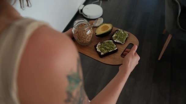 Женщина Несет Свой Завтрак Тостов Авокадо Разделочной Доске — стоковое видео