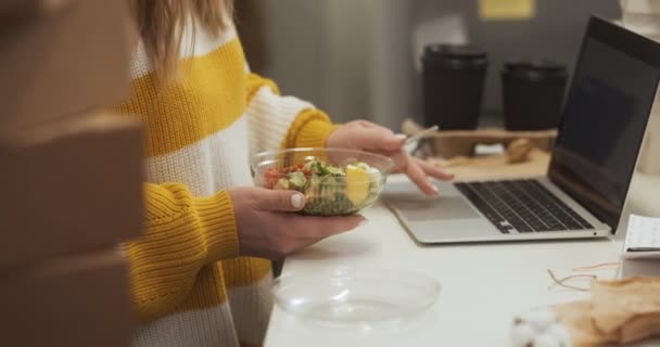 仕事中にサラダを食べる上で認識できないビジネスマンの女性を閉じます 昼食をとりながら 自宅のオフィスでラップトップ上で働く起業家の女性 — ストック動画