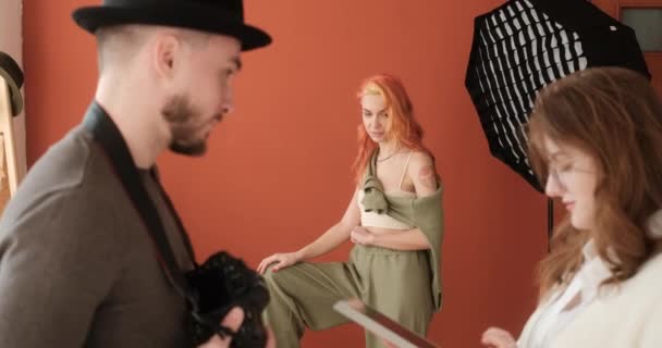 Fashion Model Waiting While Female Photographer Male Assistant Discuss Photo — Stock Video