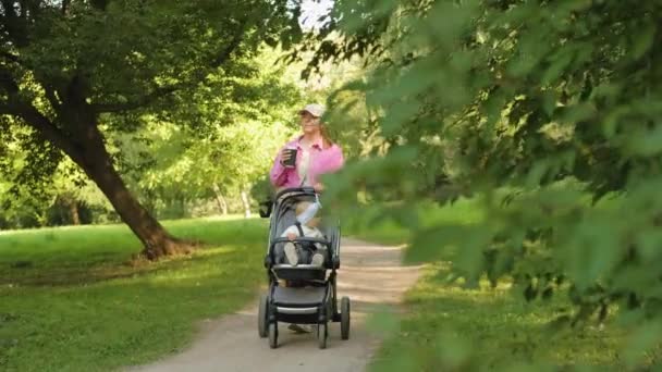Щаслива Мати Каву Під Час Прогулянки Літньому Парку Своєю Молодою — стокове відео