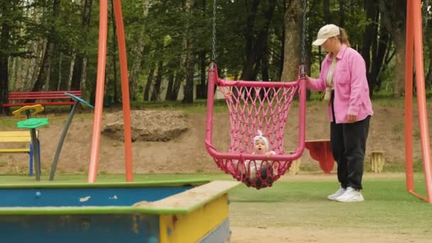 Menina Grande Balanço Uma Mãe Balançando Seu Filho Playground Parque — Vídeo de Stock