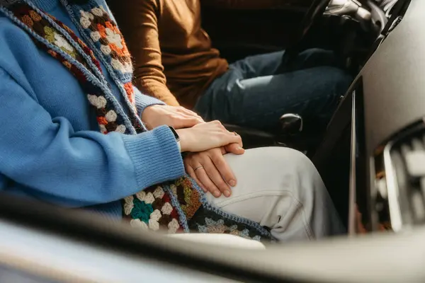 两个人坐在一辆车上 手指头相互交织 在一起旅行时表现出一种舒适和连接的姿态 免版税图库图片