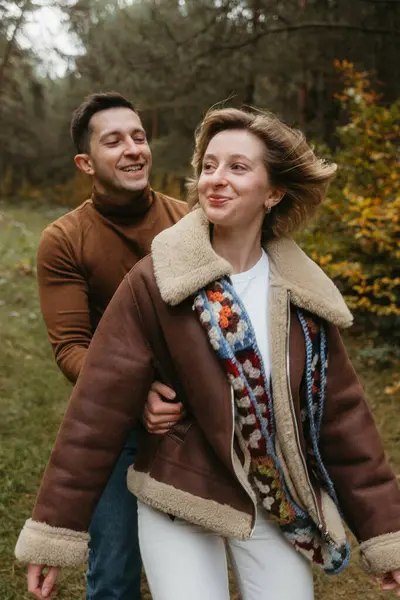 男人和女人在户外 快乐的成年人夫妇在秋天的公园里共度时光 免版税图库照片