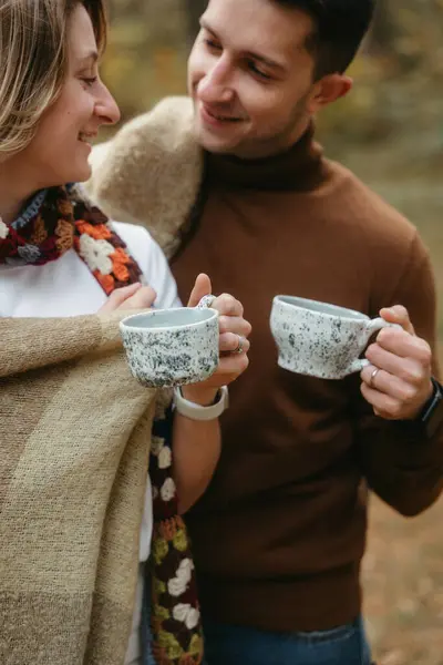 男人和女人一起站在室外笑着 手里拿着手工制作的茶杯 图库照片