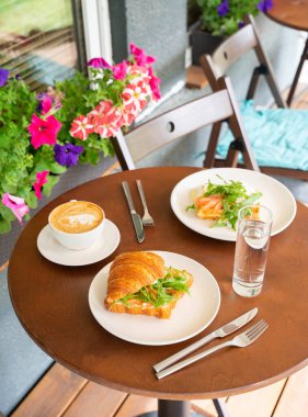 Kahvaltı konsepti kahve suyu ve somonlu kruvasan yazın veya ilkbaharda Cafe Terrace 'da kapanıyor. Yüksek kalite fotoğraf