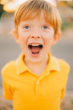 Gün batımında gülümseyen ve sarı gömlekli şirin çocuk portresi. Yaklaş. Yüksek kalite fotoğraf
