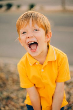 Gün batımında gülümseyen ve sarı gömlekli şirin çocuk portresi. Yaklaş. Yüksek kalite fotoğraf