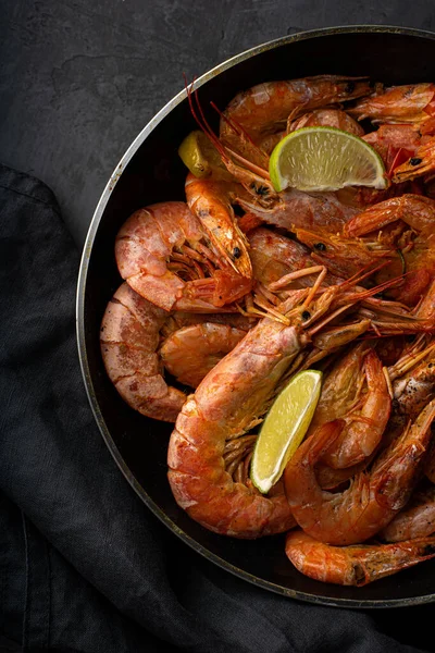 Kızartma tavasında limonlu haşlanmış Baharatlı Karides ve siyah arka planda haşlanmış Baharatlı Deniz Ürünleri. Yüksek kalite fotoğraf