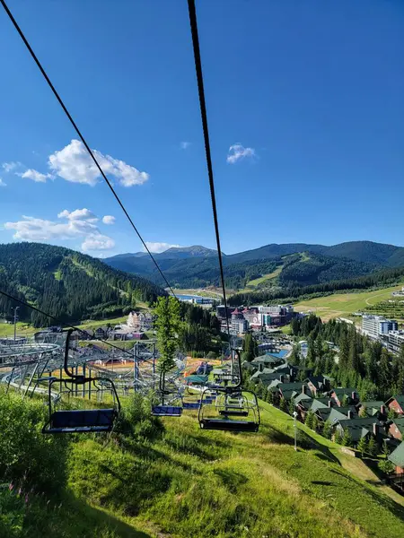 Yaz mevsiminde Bukovel 'deki kayak asansörüyle dağın eteklerine tırmanırken, aşağıdaki vadilerden süzülen yemyeşil ormanlar, kır çiçekleri ve çağlayan akarsulardan oluşan panoramik manzaralarla karşılaşacaksınız. Bukovel, Ivano-Frankivsk bölgesi, Ukrayna.