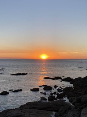 Okyanusun üzerinde günbatımının fotoğrafı.