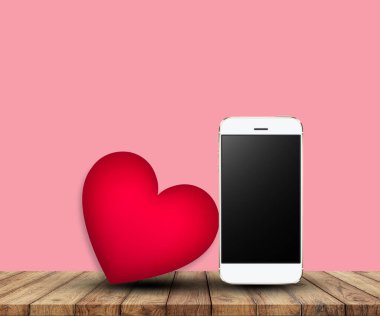 Smartphone and big heart on wooden board . valentine concept