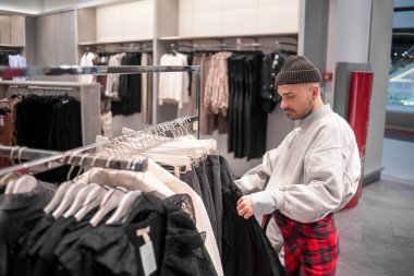 Adam giyim mağazasından alışveriş yapıyor.