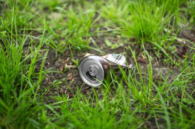 Yerde yeşil çimenler olan metal bir teneke kutu.