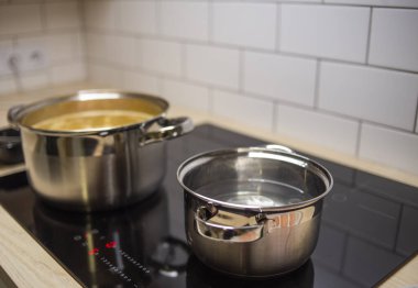 Fırında demir kaplar, modern mutfak aletleri.