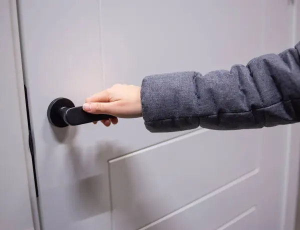 Beyaz modern kapıyı açan el.