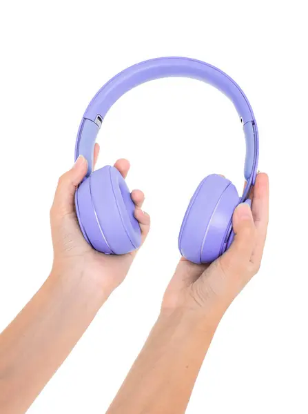 Mor bir kulaklık tutan el izole edilmiş.
