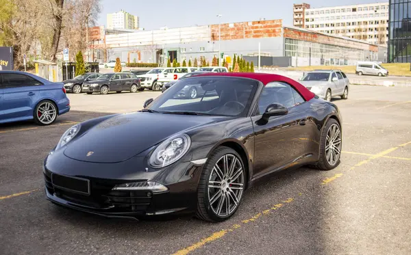 Siyah Porsche 911. Kırmızı üstü açık çatısı var.
