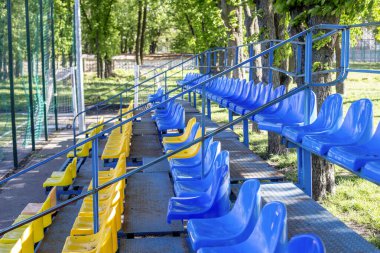 Güneşli bir günde siyah Marshall taşınabilir bluetooth hoparlörü tutan birinin yakın çekimi. İkonik markalaşma ve doğal bulanık arkaplan ile modern kablosuz ses aygıtı