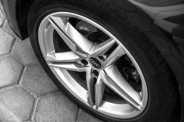 Modern bir Audi araba alaşımlı tekerin yakın plan resmi, siyah-beyaz, ayrıntılı ve desenli.