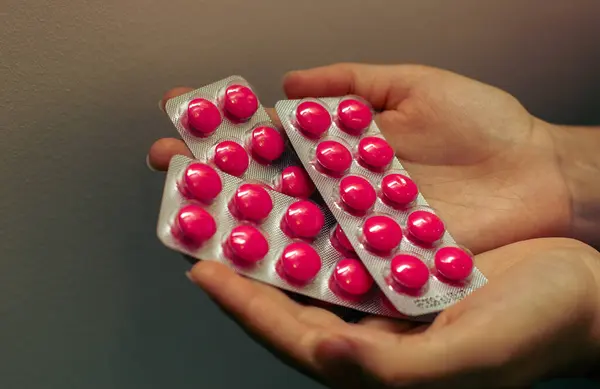 Kişi Elleri Üç Pembe Hap Paketi Tutuyor