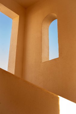 Kemerli pencere ve güneş ışığıyla geleneksel kil duvar