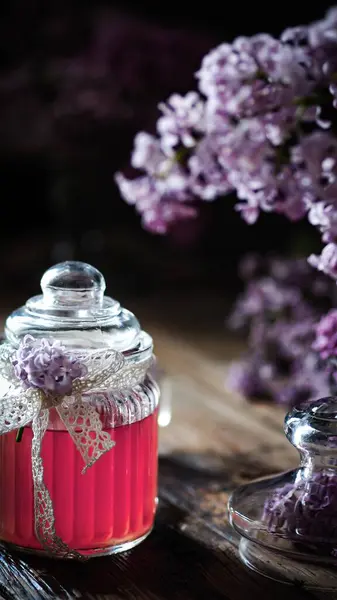 Kavanozda leylak çiçeği. Bardakta pembe içecek. bahar çiçekli leylak