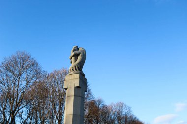 Vigelandsparken, Vigeland Heykel Parkı, Frogner Park, Oslo, 27 Mart 2016: Gustav Vigeland 'ın bronz heykeli. Mavi gökyüzünde bacaklarını saran bir adam üzgün görünüyor.