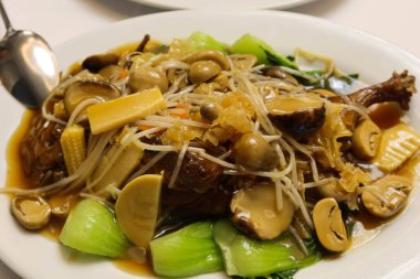 Çin usulü ağır ateşte pişirilmiş Shiitake mantarı, içinde Bebek Bok Choy, ördek eti, Enoki ve sos. Restoranda çekilen lüks bir yemek..