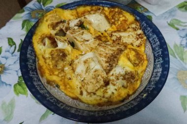 Hong Kong usulü ev yapımı kızarmış yumurta ve soya peynirli soya peynirini mavi ve beyaz tabağa koy.