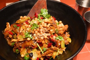 Sichuan usulü baharatlı, fındık, sığır dili, sığır eti midesi, mahzen, et ve erişte ile siyah bir kasede.