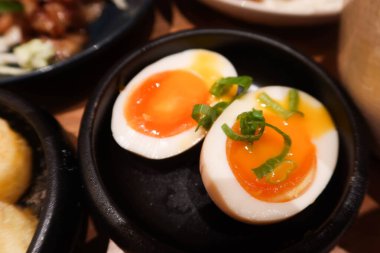 Japon baharatlı haşlanmış yumurtasına yakın durun ya da siyah bir kasede taze soğanlı Onsen Tamago denilebilir.