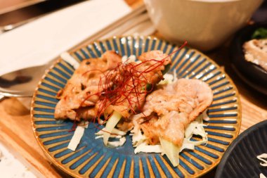 Japon usulü kızarmış domuz etini mavi tabakta yakın plan.