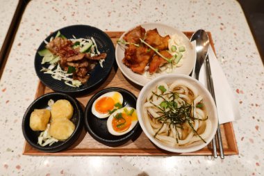 Japon sofrası, çorba, haşlanmış yumurta, kızarmış domuz eti, kızarmış tavuk ve kaşık çubuklu kızarmış yumurta tofusu da dahil olmak üzere 5 farklı yemek.