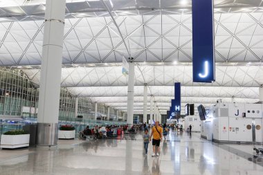 Hong Kong Uluslararası Havalimanı, Hong Kong, 18 Temmuz 2024. Gece havaalanı. Aile J 'deki kalkış salonunda yürüyen insanlar var.
