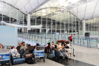 Hong Kong Uluslararası Havalimanı, Lamma Adası, Hong Kong - 22 Temmuz 2024: HK havaalanında gece giriş ve kalkış için bekleyen insanlar