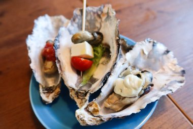 Çiğ çiğ saşimi istiridye, peynir, vişneli domates, tatlı ve ekşi sos ve mayonez.