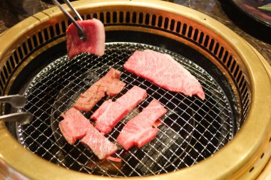 Izgara çiğ Japon Matsusaka sığır eti yakiniku ve yuvarlak ızgara.