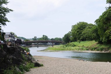 Ise Grand Shrine, Ise, Mie, Japonya - 19 Temmuz 2024: Güneşli bir günde her iki yakasında nehir ve ağaçlar olan köprü veya iç tapınakta 
