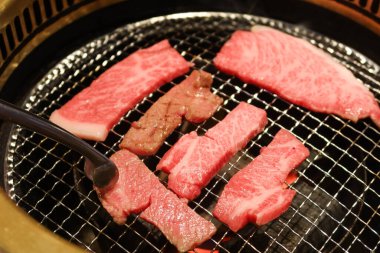 Izgara çiğ Japon Matsusaka sığır eti yakiniku ve yuvarlak ızgara.
