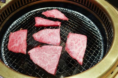 Izgara çiğ Japon Matsusaka sığır eti yakiniku ve yuvarlak ızgara.