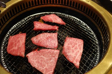 Sobanın üstünde iki şarjör var. İçinde bir parça et olan çiğ Japon waygu bifteği. 