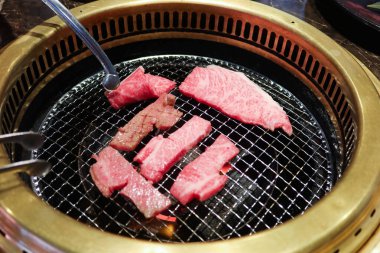 Sobanın üstünde iki şarjör var. İçinde bir parça et olan çiğ Japon waygu bifteği. 