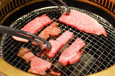 Sobanın üstünde iki şarjör var. İçinde bir parça et olan çiğ Japon waygu bifteği. 