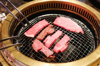 Sobanın üstünde iki şarjör var. İçinde bir parça et olan çiğ Japon waygu bifteği. 