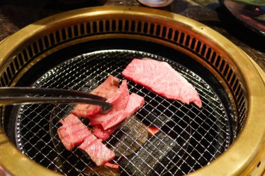 Sobanın üstünde iki şarjör var. İçinde bir parça et olan çiğ Japon waygu bifteği. 