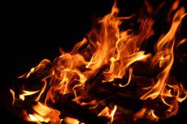 Geceleri yanan odun kömürlerinden oluşan bir kamp ateşinde, alevlerin kapağını kapatın.